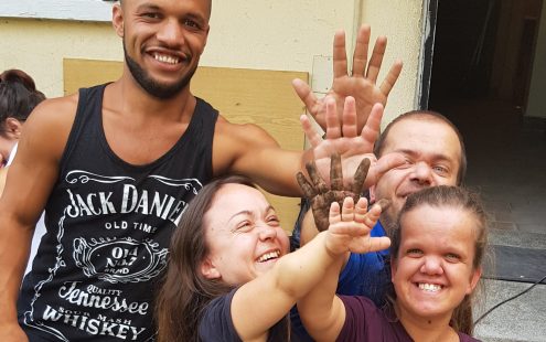 Five members of "The Little People of Bulgaria" association give high five to each other in front of the entrance of the service center | Pipelife